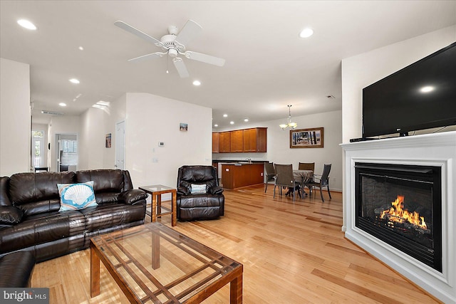 living room featuring ceiling fan and light hardwood / wood-style flooring