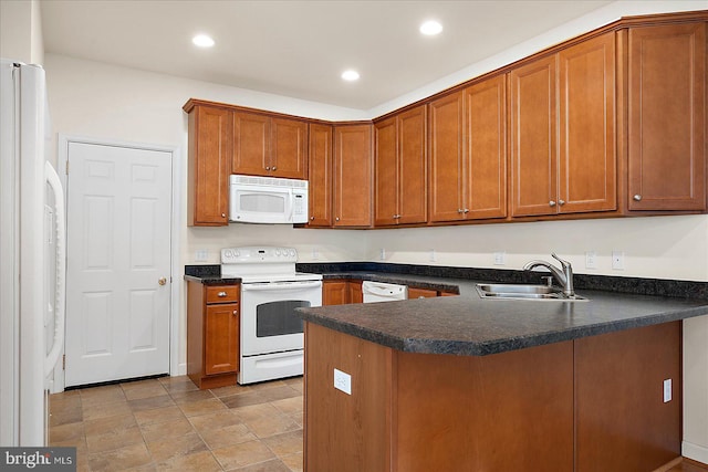 kitchen with sink, white appliances, and kitchen peninsula