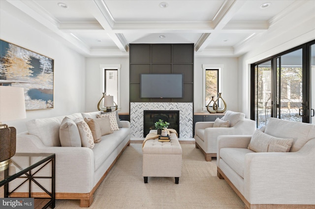 living room featuring coffered ceiling, a tiled fireplace, and beam ceiling