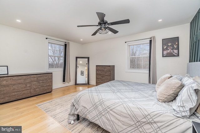 bedroom featuring multiple windows, ceiling fan, and light wood-type flooring