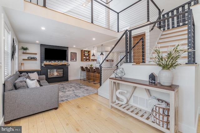 living room with a fireplace and light wood-type flooring