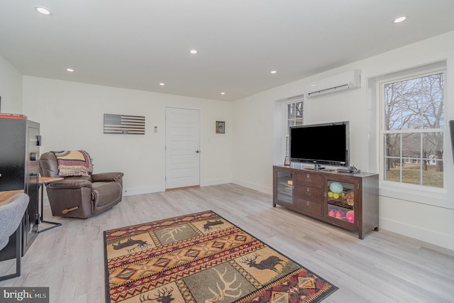 living room featuring a wall mounted air conditioner and light hardwood / wood-style floors