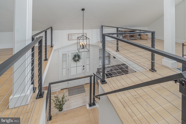 stairway featuring hardwood / wood-style flooring and a chandelier