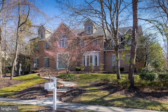 view of front of property with a front lawn and brick siding