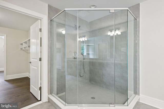 bathroom featuring an enclosed shower and wood-type flooring