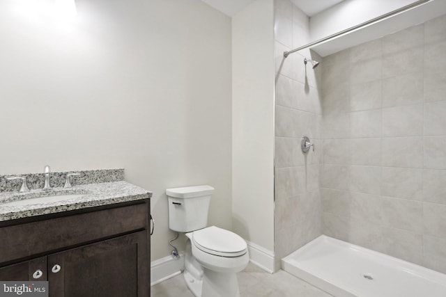 bathroom with vanity, tiled shower, and toilet