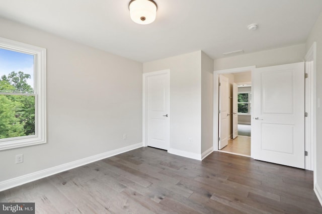 unfurnished bedroom with dark hardwood / wood-style flooring