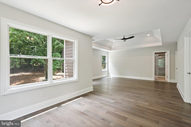 empty room featuring ceiling fan, a raised ceiling, and hardwood / wood-style floors