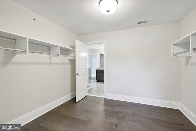 spacious closet with dark hardwood / wood-style floors