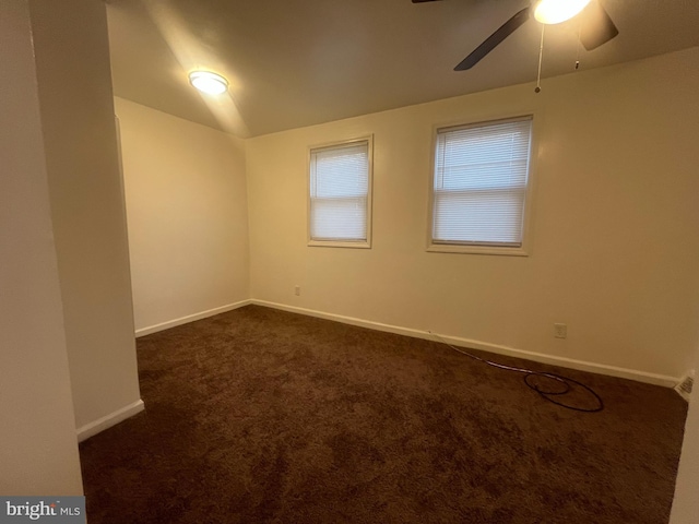 empty room with dark carpet and ceiling fan