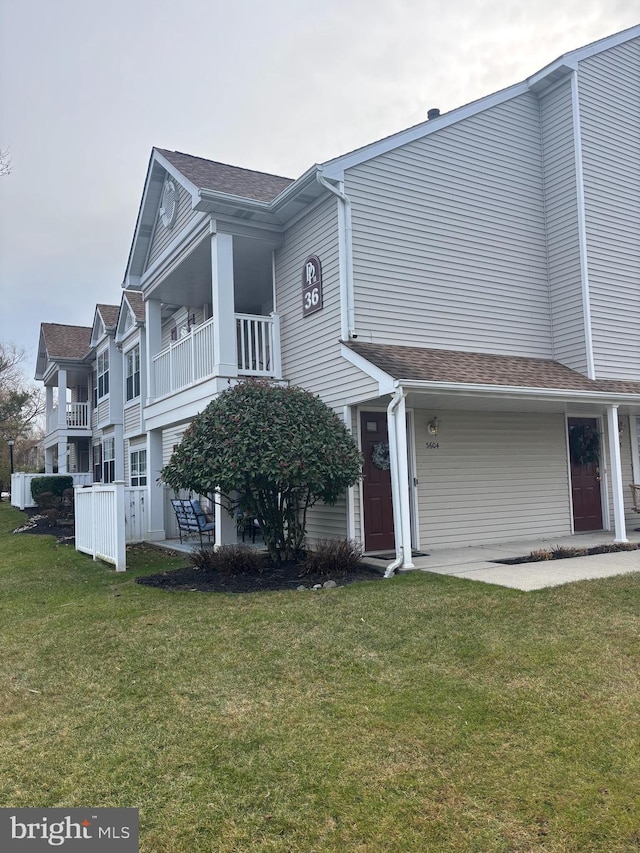 view of front of home featuring a balcony and a front lawn