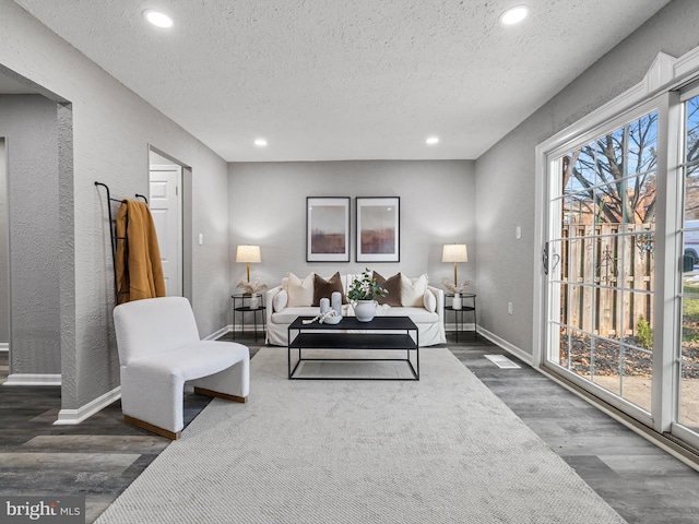 living room with dark wood-type flooring and a textured ceiling