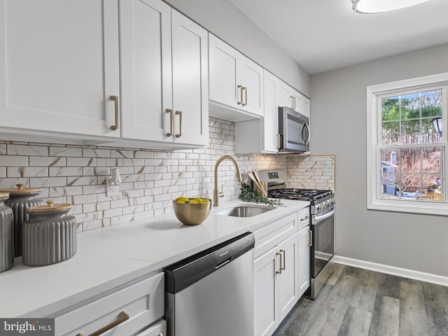 kitchen with dark wood-type flooring, stainless steel appliances, sink, and white cabinets