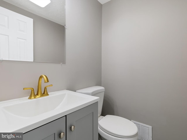 bathroom with vanity, a textured ceiling, and toilet