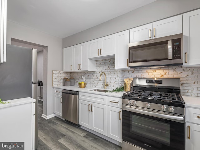 kitchen with appliances with stainless steel finishes, sink, white cabinets, and decorative backsplash