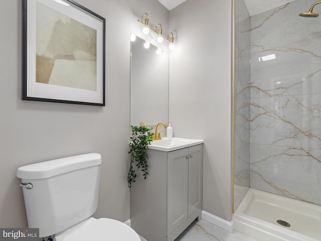 bathroom featuring vanity, a tile shower, and toilet