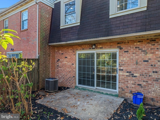 rear view of house featuring central AC unit and a patio