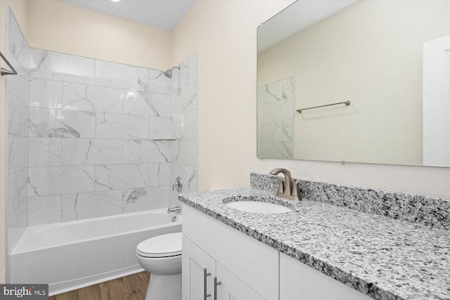 bathroom featuring vanity, bathing tub / shower combination, wood finished floors, and toilet