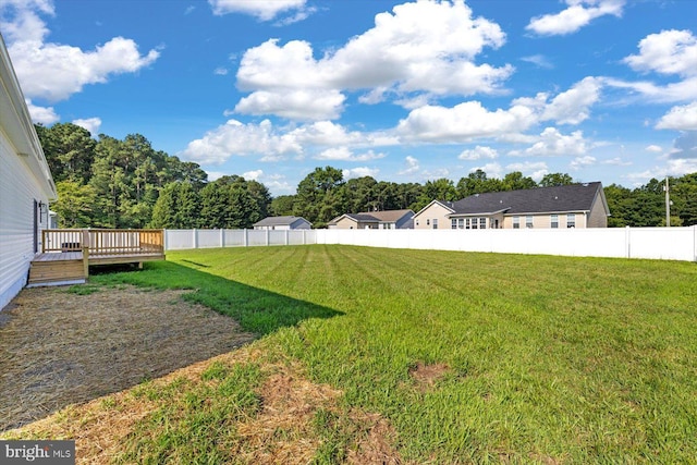 view of yard featuring a wooden deck and fence