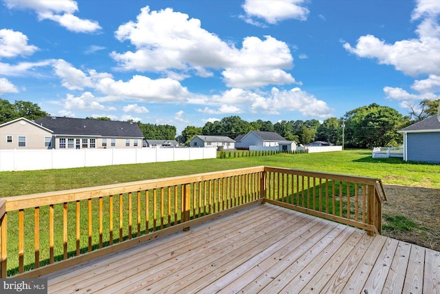 deck featuring a lawn, fence, and a residential view