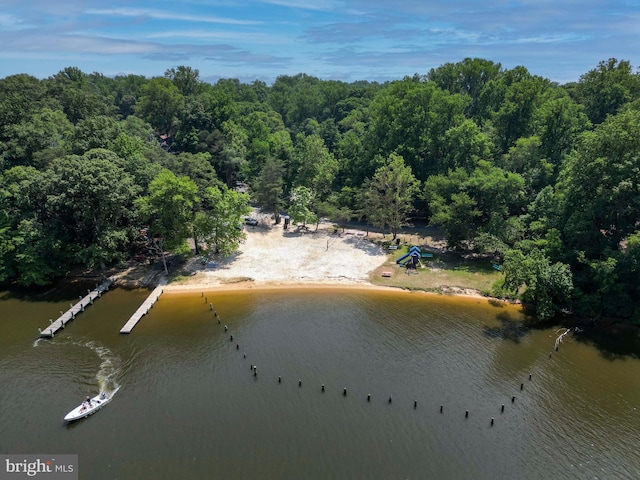 drone / aerial view featuring a water view and a forest view