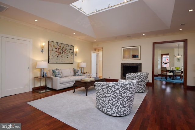 living room with a raised ceiling, vaulted ceiling, dark wood-type flooring, and crown molding