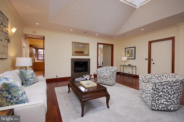 living room featuring hardwood / wood-style flooring, a tray ceiling, vaulted ceiling, and crown molding