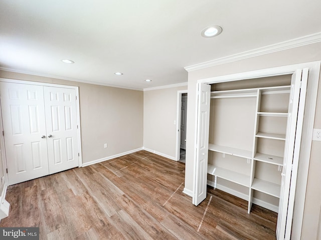 unfurnished bedroom featuring crown molding and hardwood / wood-style flooring