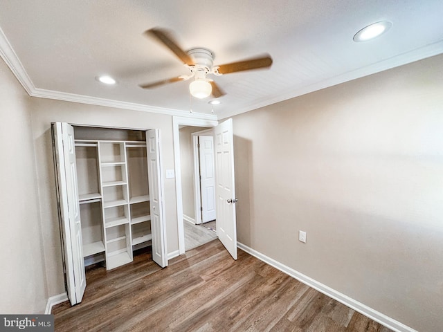 unfurnished bedroom with hardwood / wood-style flooring, ornamental molding, a closet, and ceiling fan