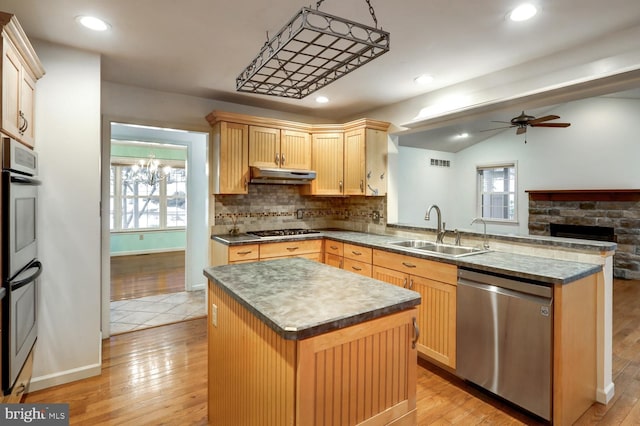 kitchen featuring light brown cabinetry, sink, kitchen peninsula, a kitchen island, and stainless steel appliances