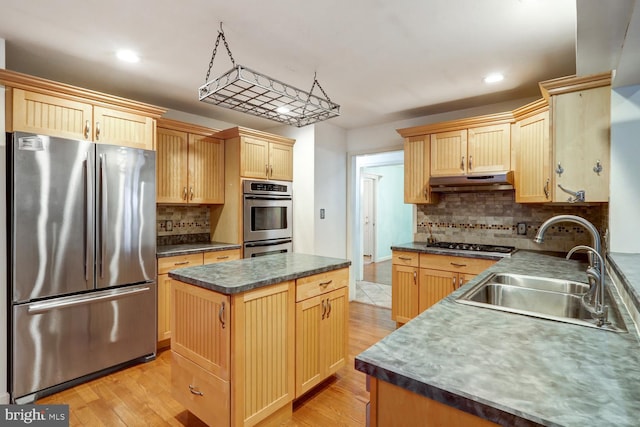 kitchen featuring sink, light hardwood / wood-style flooring, stainless steel appliances, a center island, and light brown cabinets