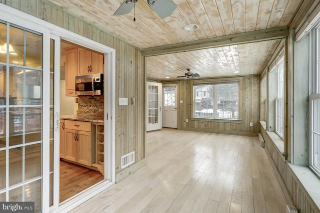 unfurnished sunroom featuring wooden ceiling and ceiling fan