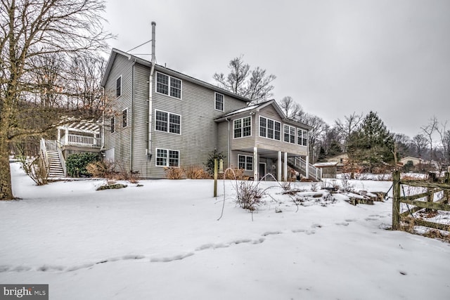 snow covered house featuring a deck and a sunroom