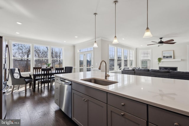 kitchen featuring sink, hanging light fixtures, ornamental molding, appliances with stainless steel finishes, and dark hardwood / wood-style floors