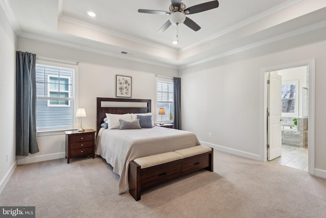 bedroom featuring light carpet, crown molding, a raised ceiling, and ensuite bathroom