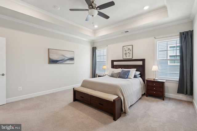 carpeted bedroom with a raised ceiling, ornamental molding, and ceiling fan