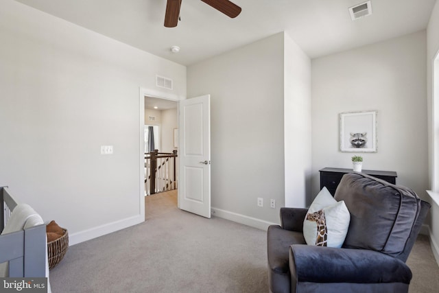 living area with light carpet and ceiling fan