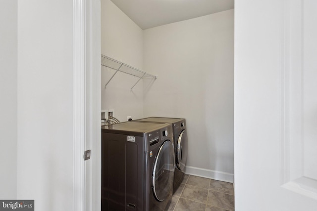 clothes washing area featuring washing machine and dryer and light tile patterned flooring