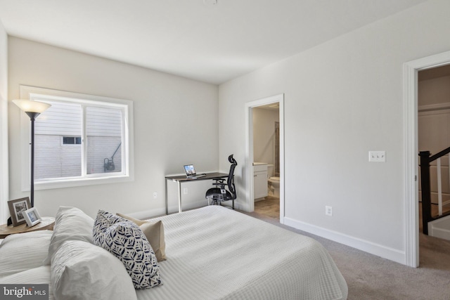 bedroom with connected bathroom and light carpet