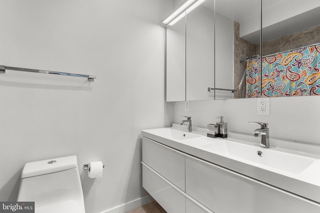 bathroom with vanity, curtained shower, and toilet