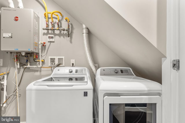 laundry room with water heater and washer and dryer