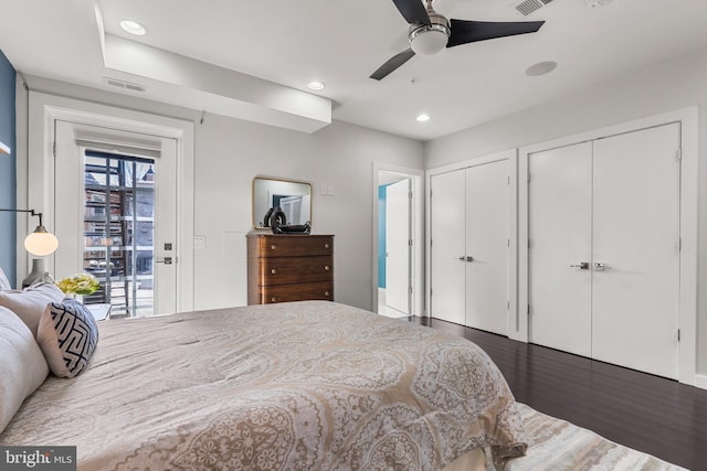 bedroom with multiple closets, dark wood-type flooring, access to exterior, and ceiling fan