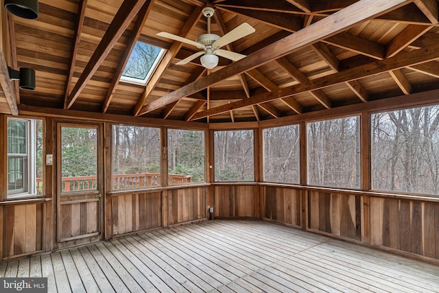 unfurnished sunroom featuring lofted ceiling with skylight, plenty of natural light, and ceiling fan