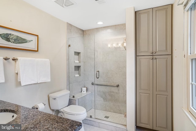 bathroom with an enclosed shower, vanity, and toilet