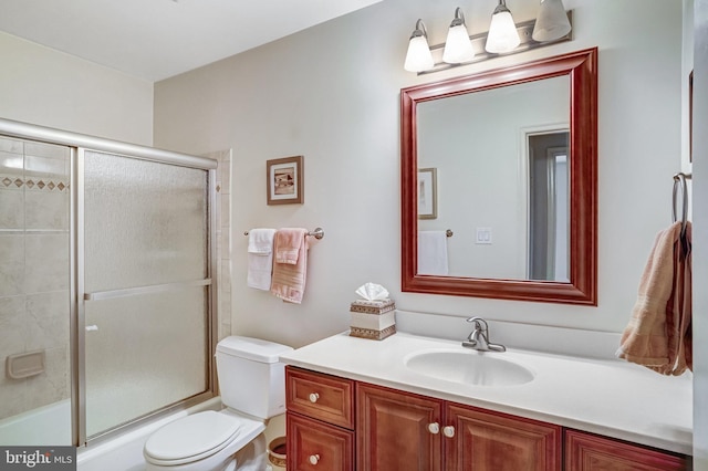 full bathroom featuring vanity, enclosed tub / shower combo, and toilet