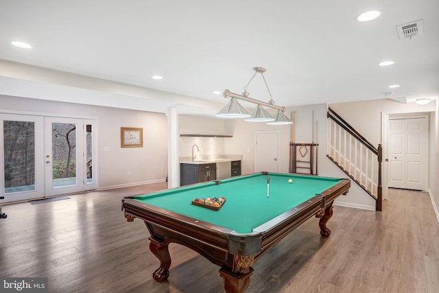 game room with french doors, hardwood / wood-style floors, pool table, and wet bar