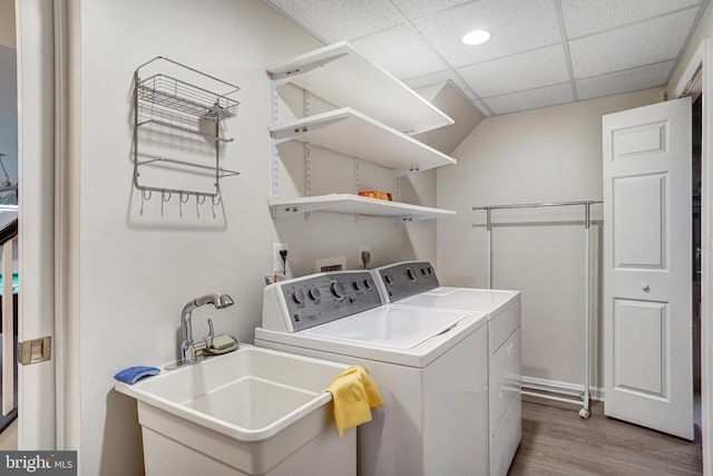 laundry room featuring sink, independent washer and dryer, and light hardwood / wood-style floors