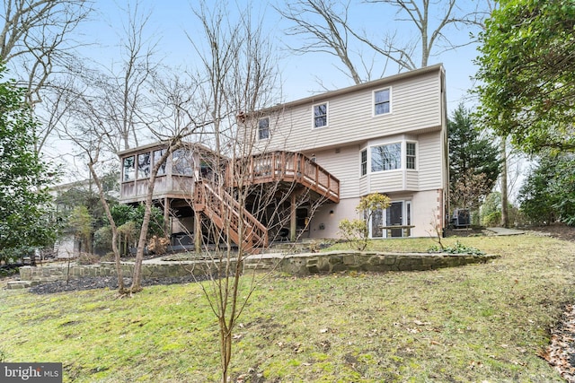 back of property featuring a wooden deck and a yard