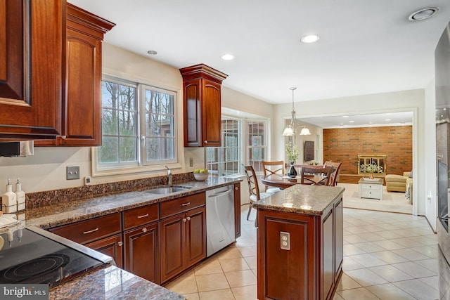 kitchen featuring decorative light fixtures, stovetop, sink, a center island, and stainless steel dishwasher