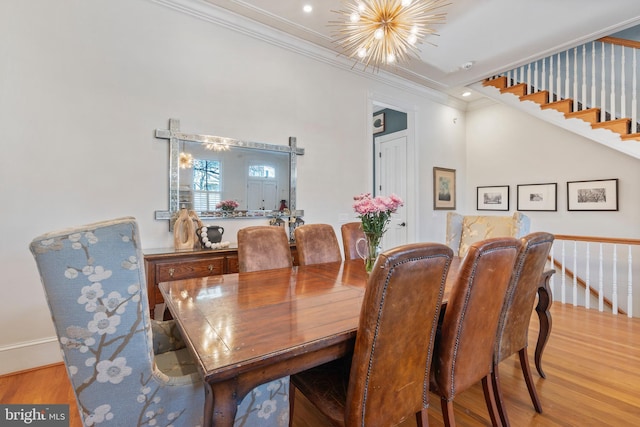 dining room featuring ornamental molding, a chandelier, and light hardwood / wood-style floors